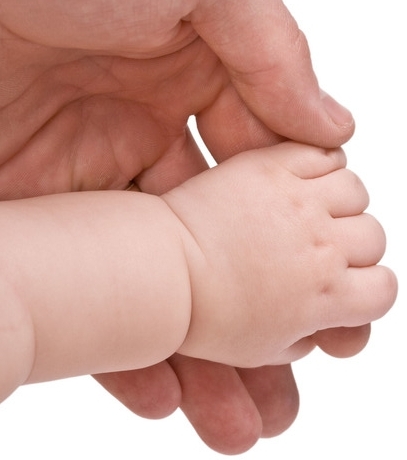 mano di adulto che stringe la mano di un neonato